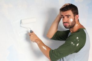 Stressed out male painting his home